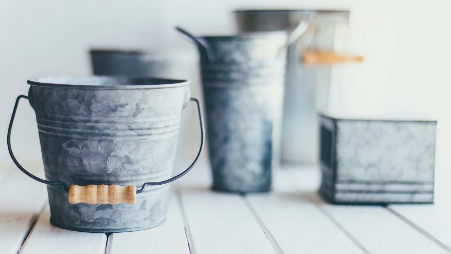 gray steel bucket on brown wooden bucket