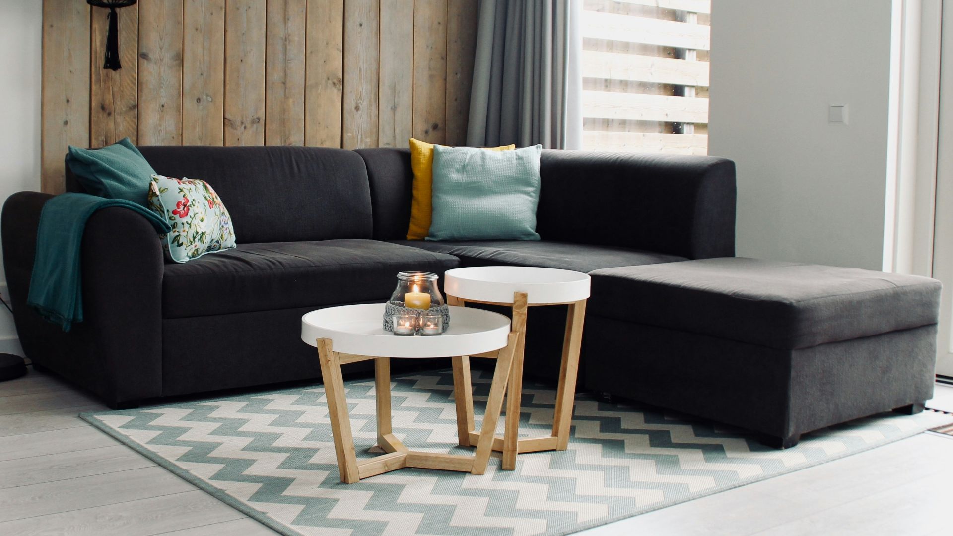 light candle on round white coffee table and sectional sofa