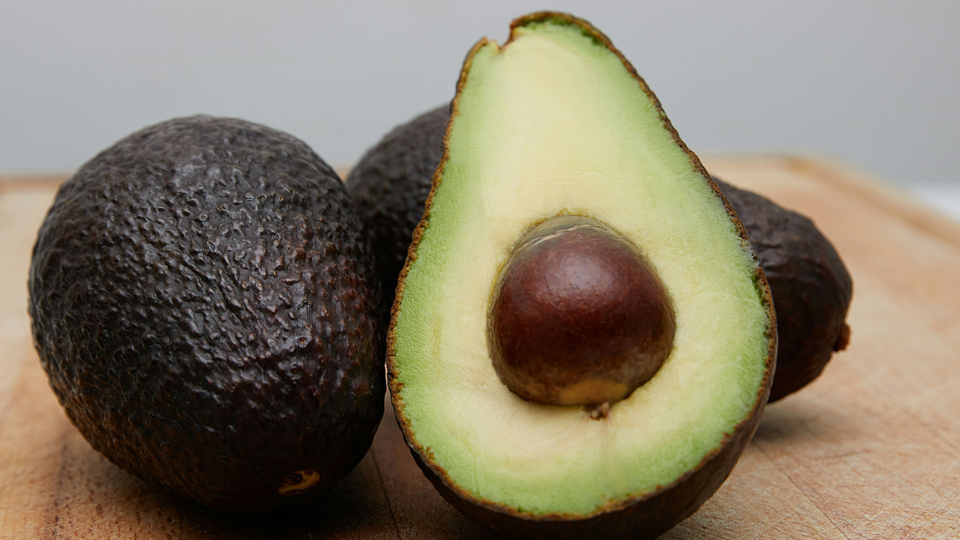 sliced avocado fruit on brown wooden table