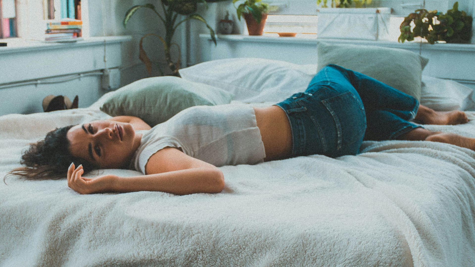 woman in blue denim shorts lying on bed