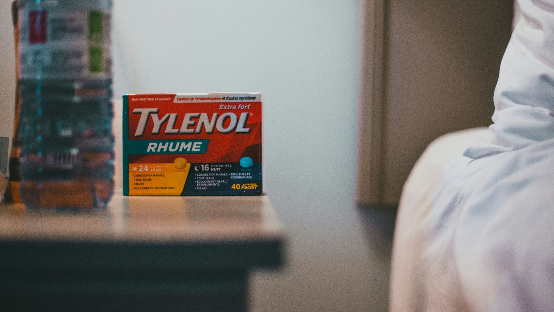 a bottle of tylenol next to a bed