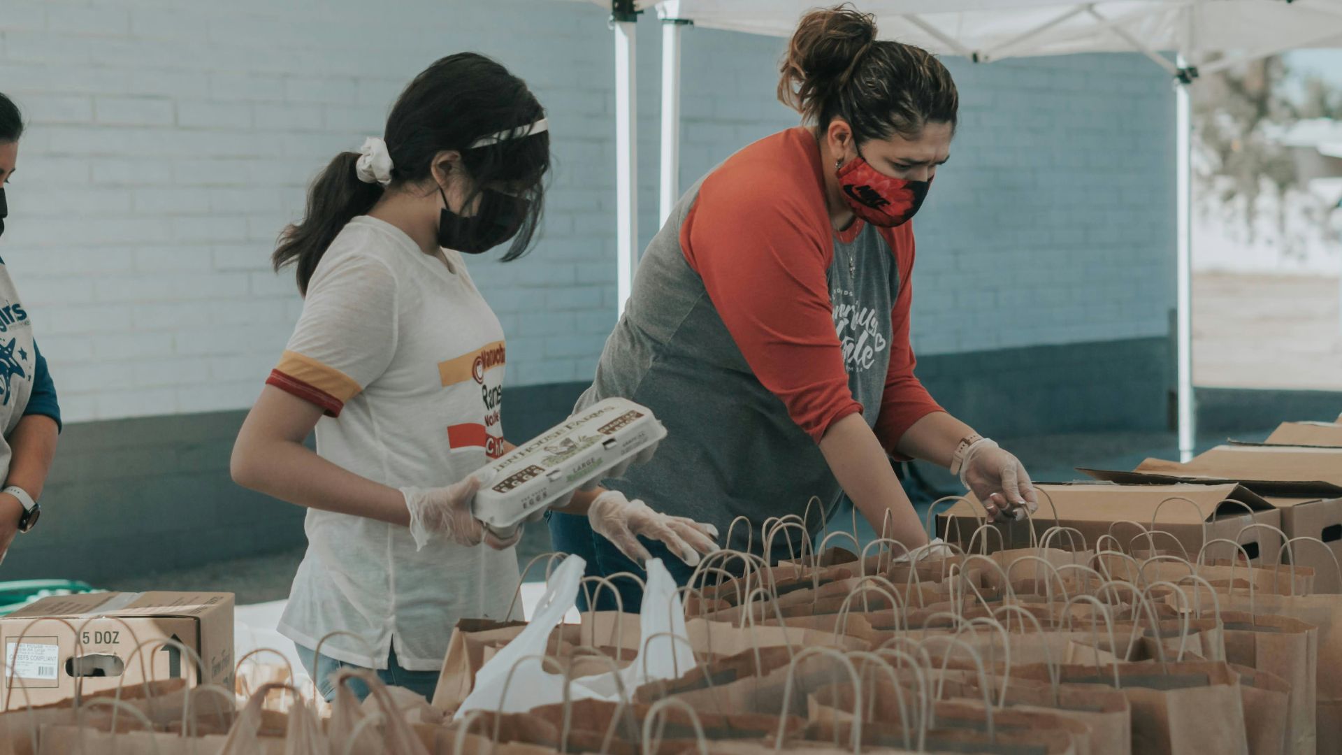 man in red t-shirt holding white plastic bottle