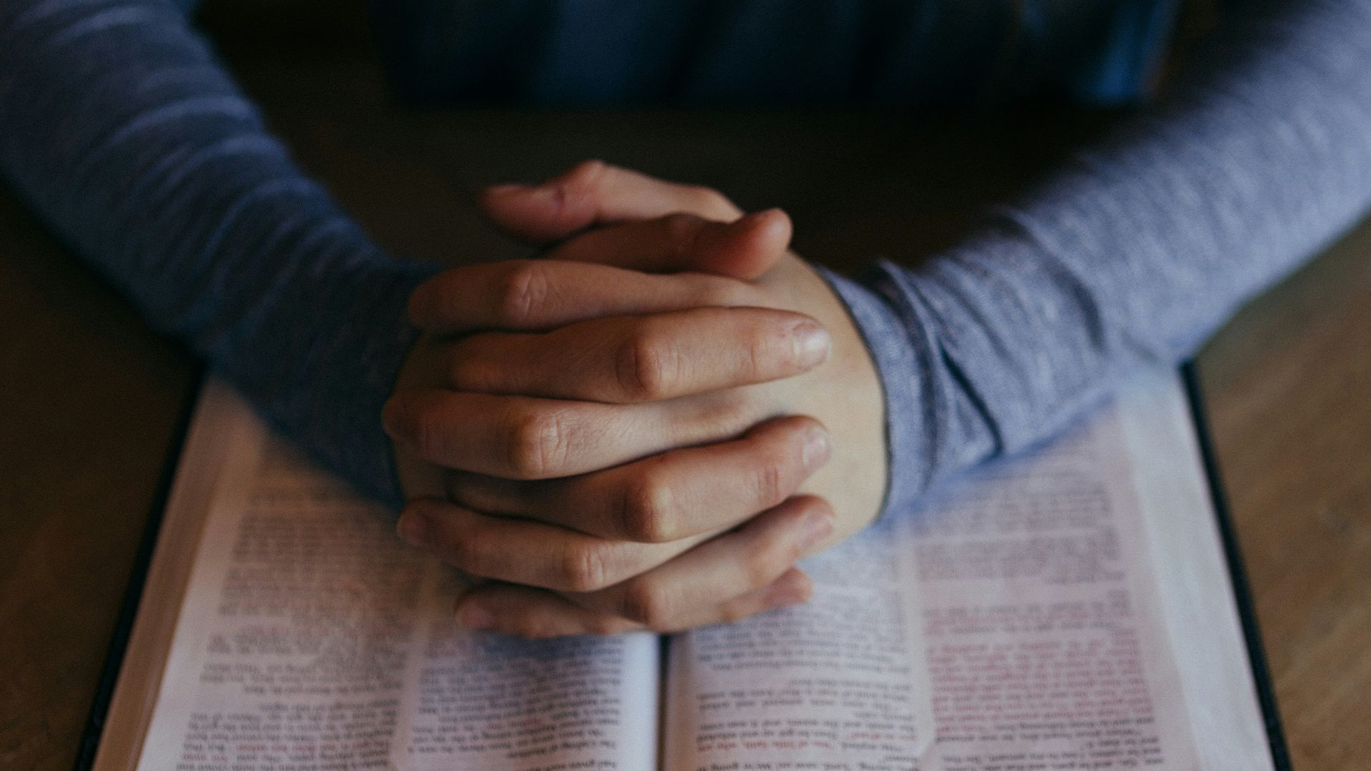 man holding his hands on open book