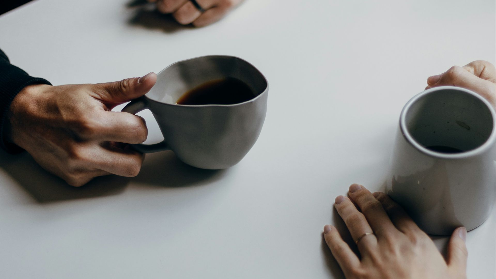a couple of people sitting at a table with cups of coffee