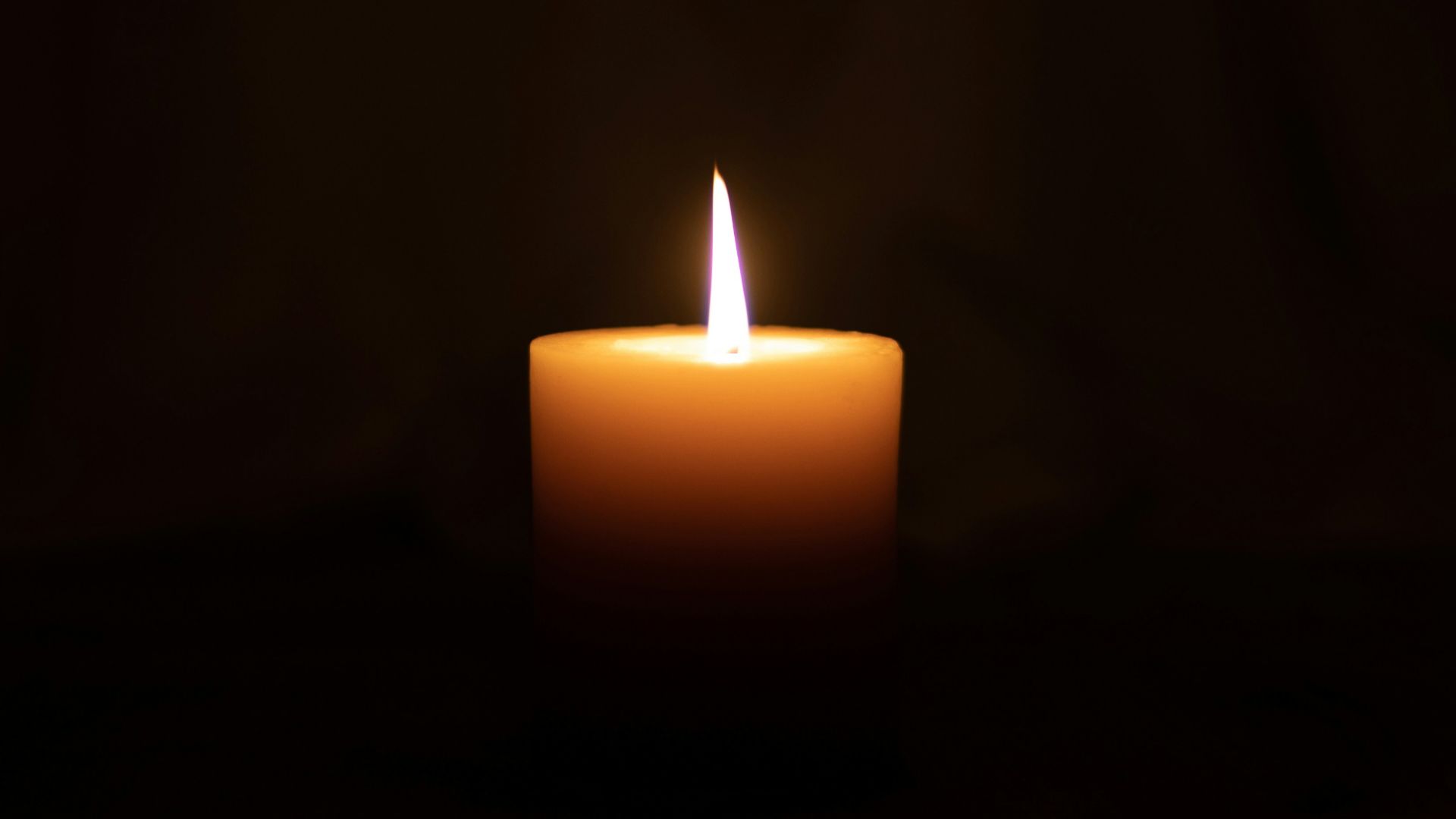 lighted candle in dark room