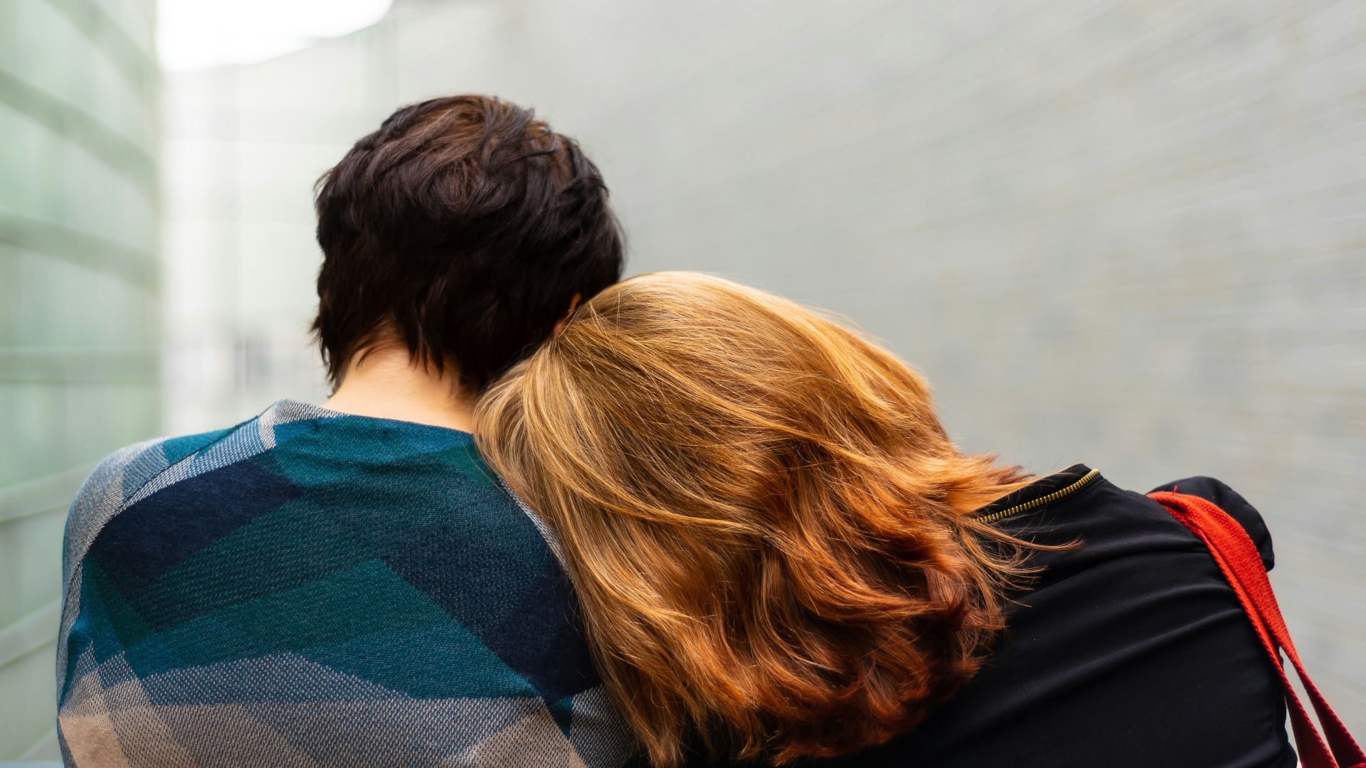 a woman rests her head on another person's shoulder