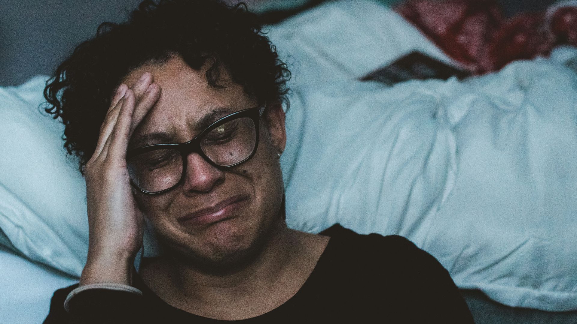 person crying beside bed