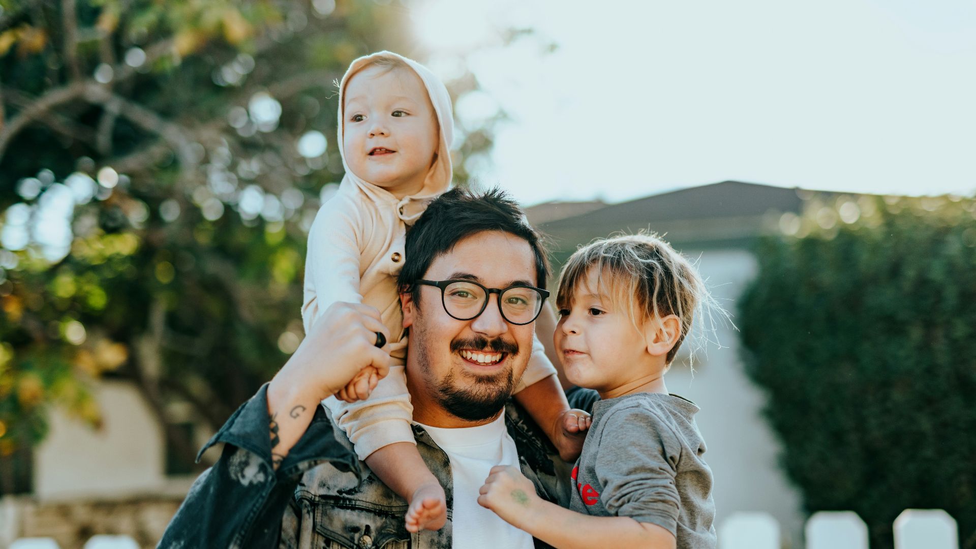 man in white shirt carrying girl in gray shirt