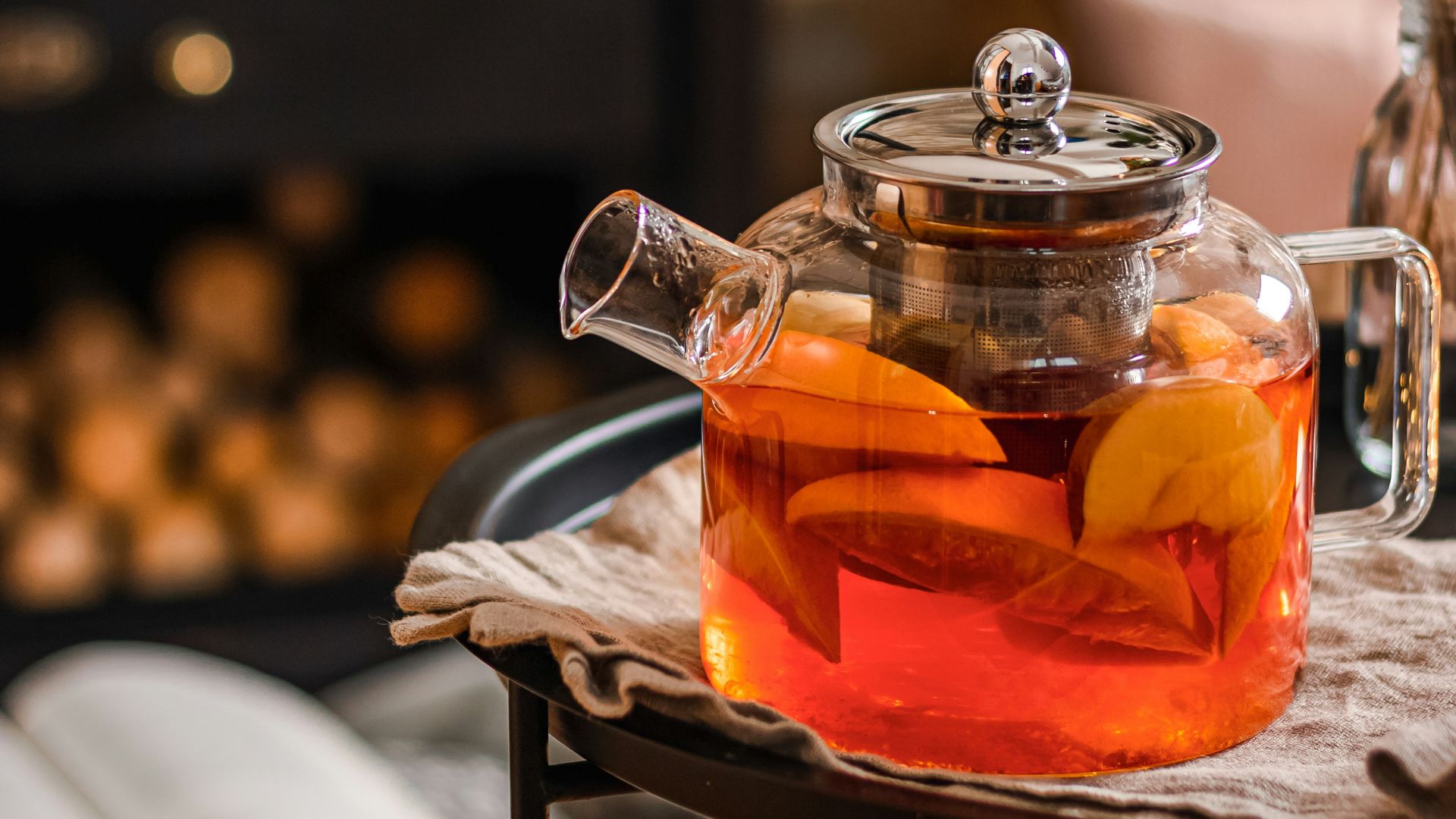 a tea pot filled with tea next to a fire place