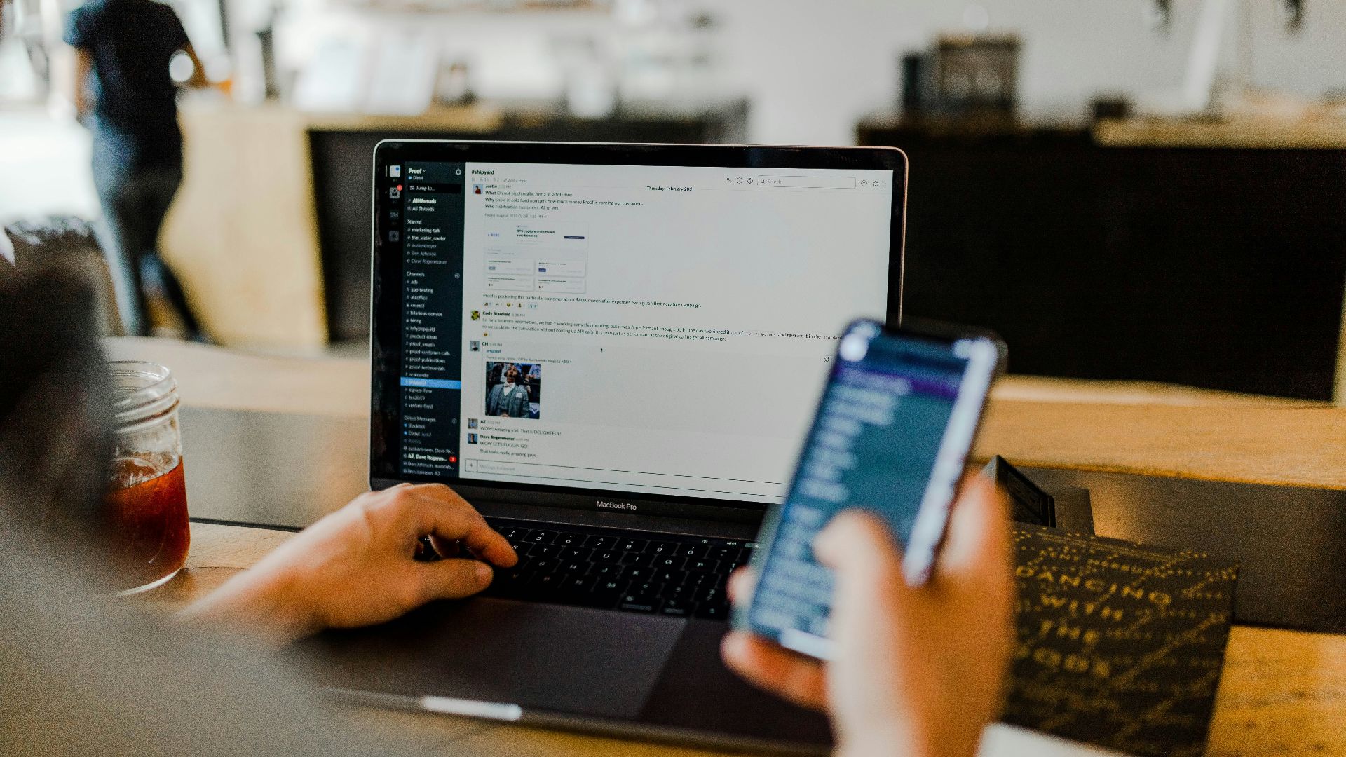 person using phone and laptop