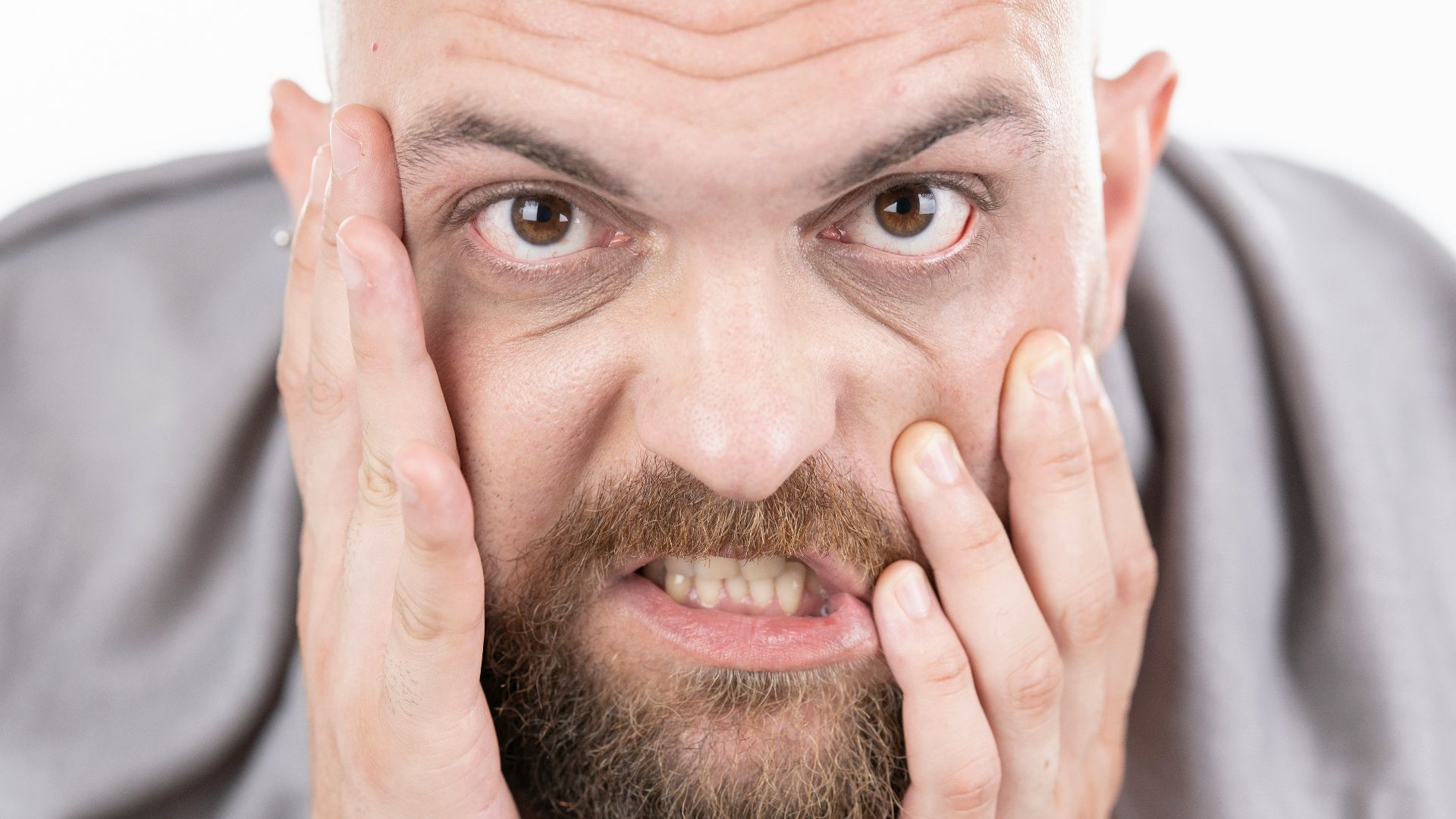 man in gray dress shirt covering his face