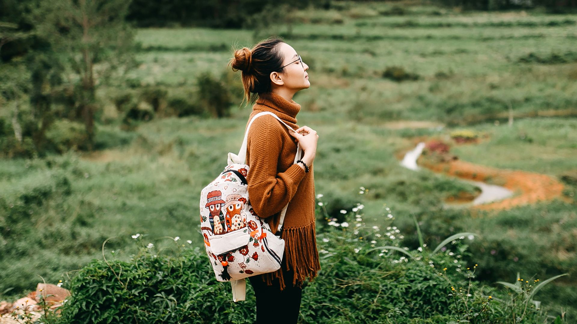 woman standing in the middle of grass field