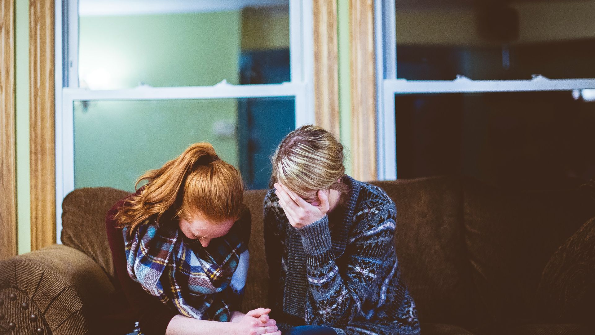 man and woman sitting on sofa in a room