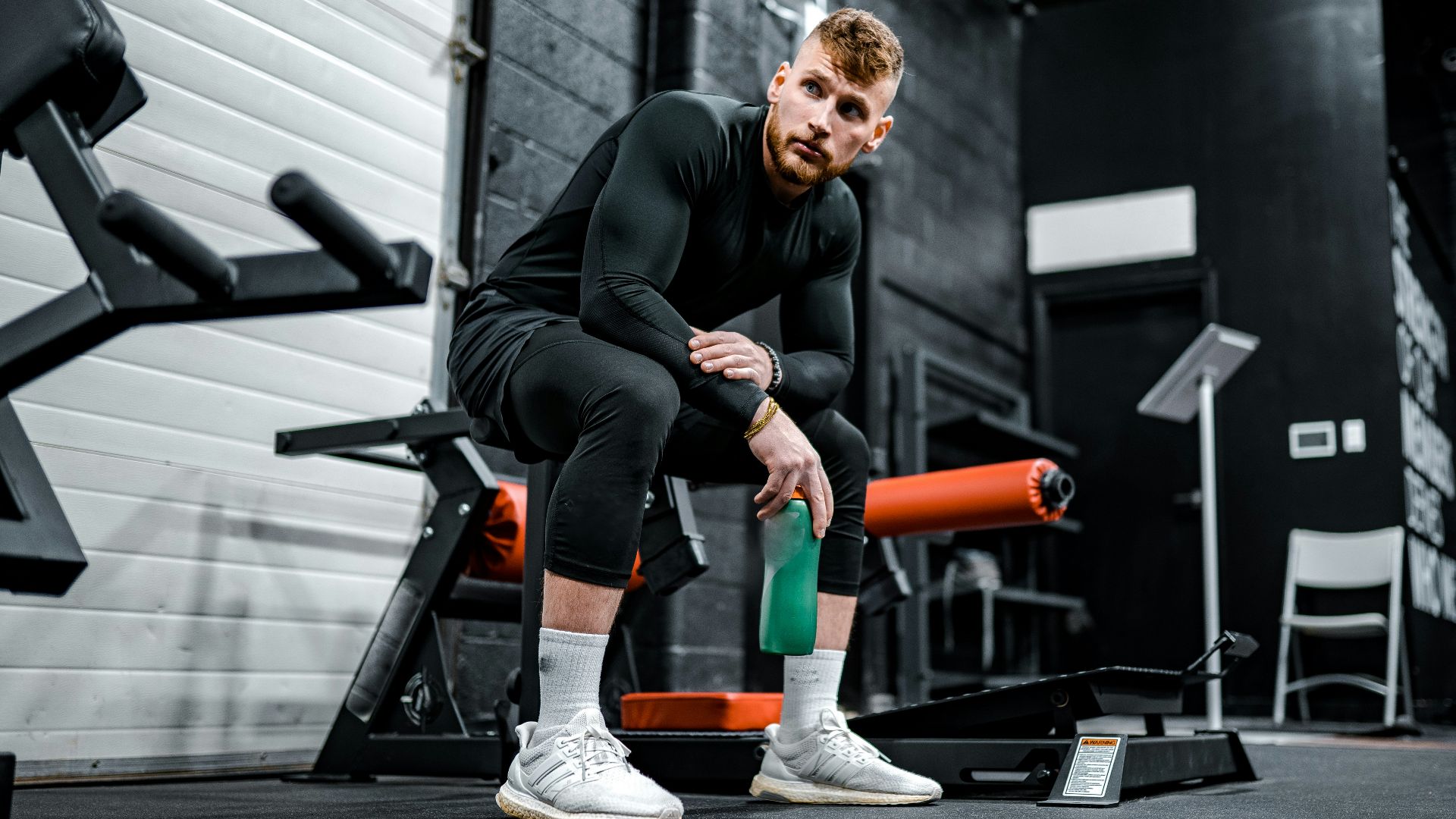 woman in black long sleeve shirt and black pants sitting on exercise equipment