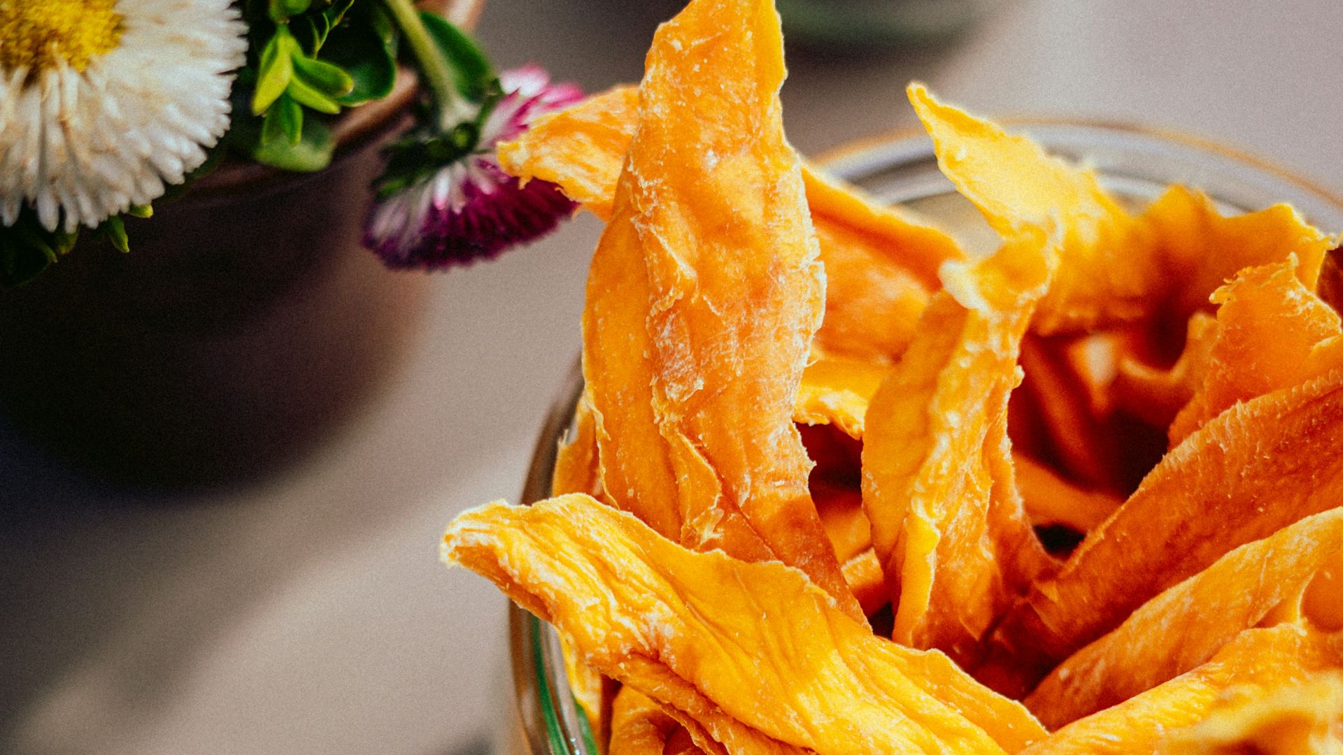 a bowl of pumpkin chips next to a bowl of dried pumpkins