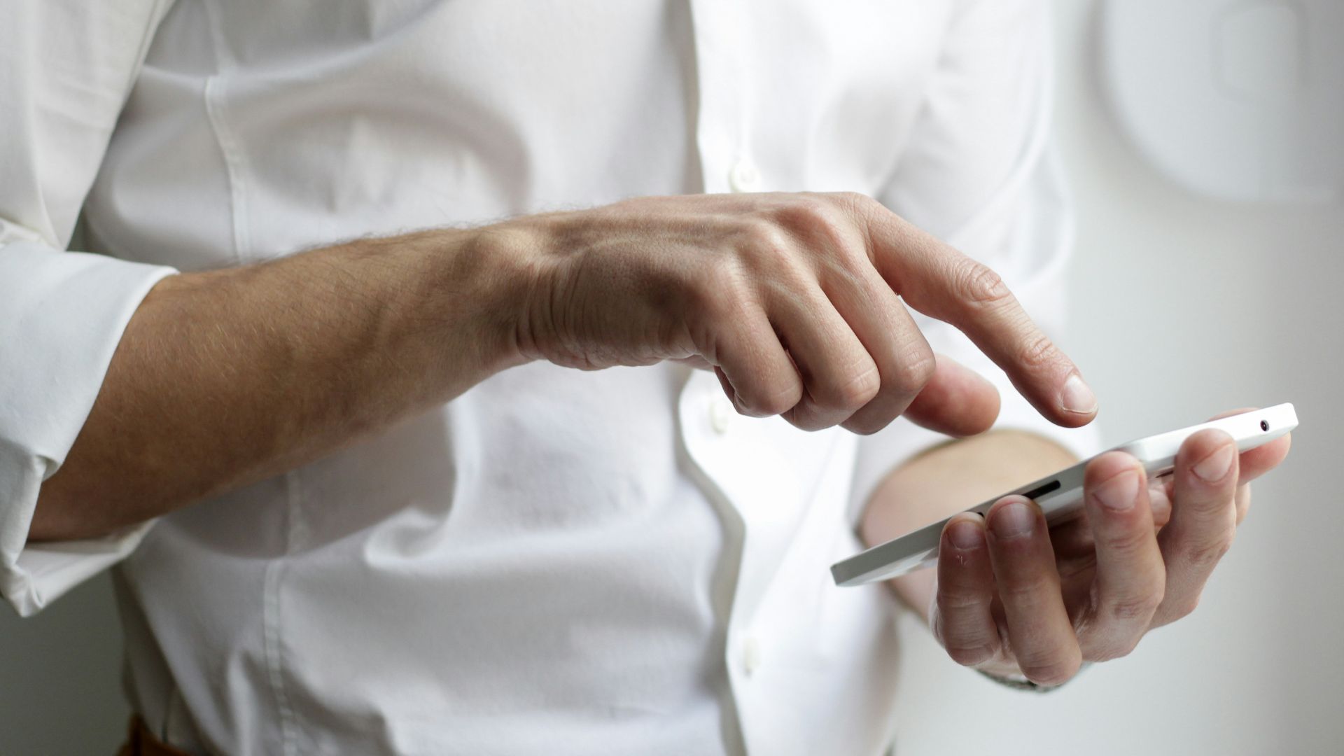 person holding white Android smartphone in white shirt