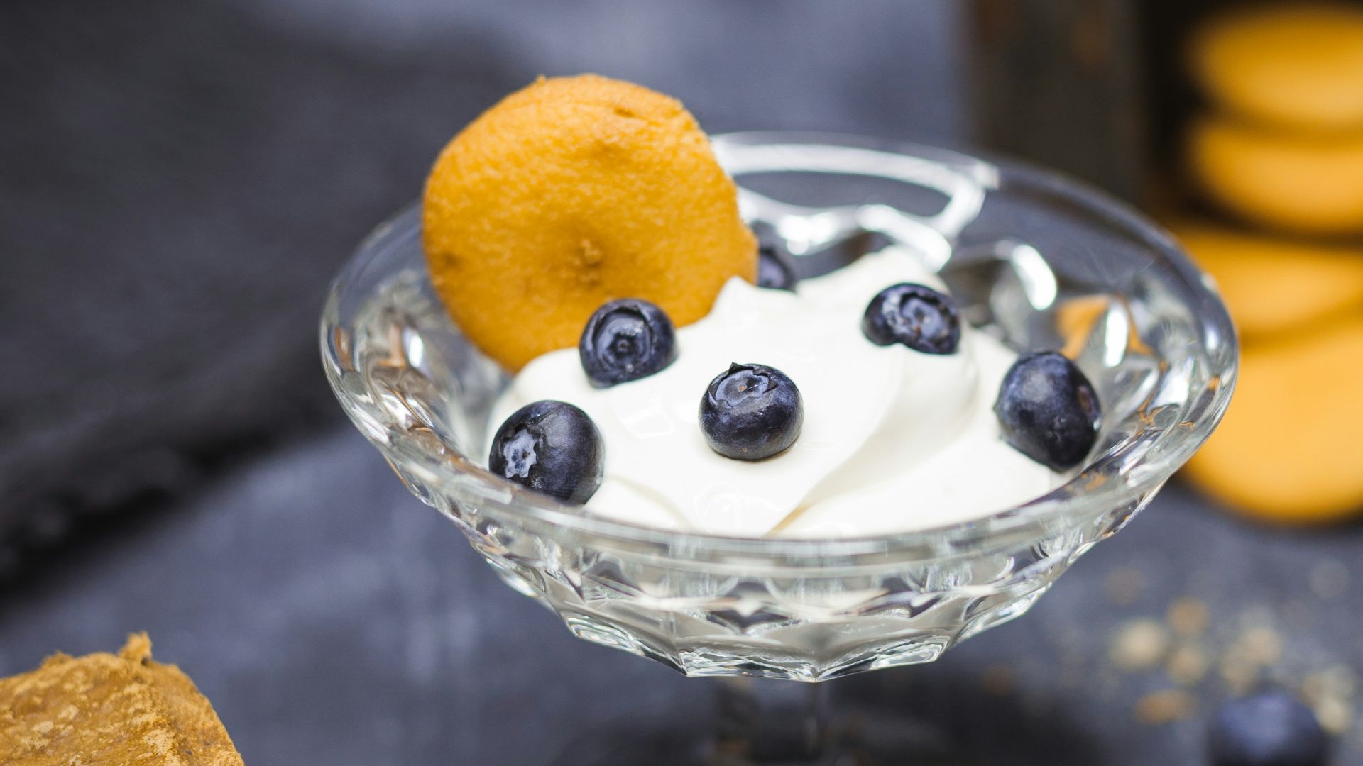 shallow focus photography of yoghurt in glass with blueberries on top