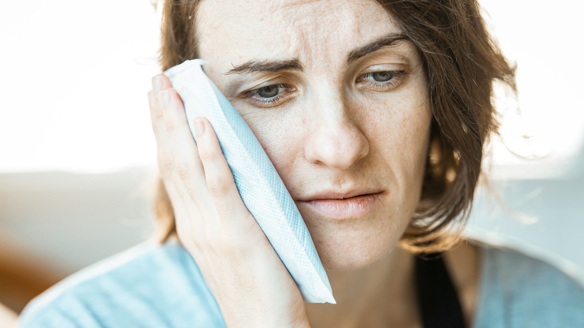 woman in black tank top holding white textile