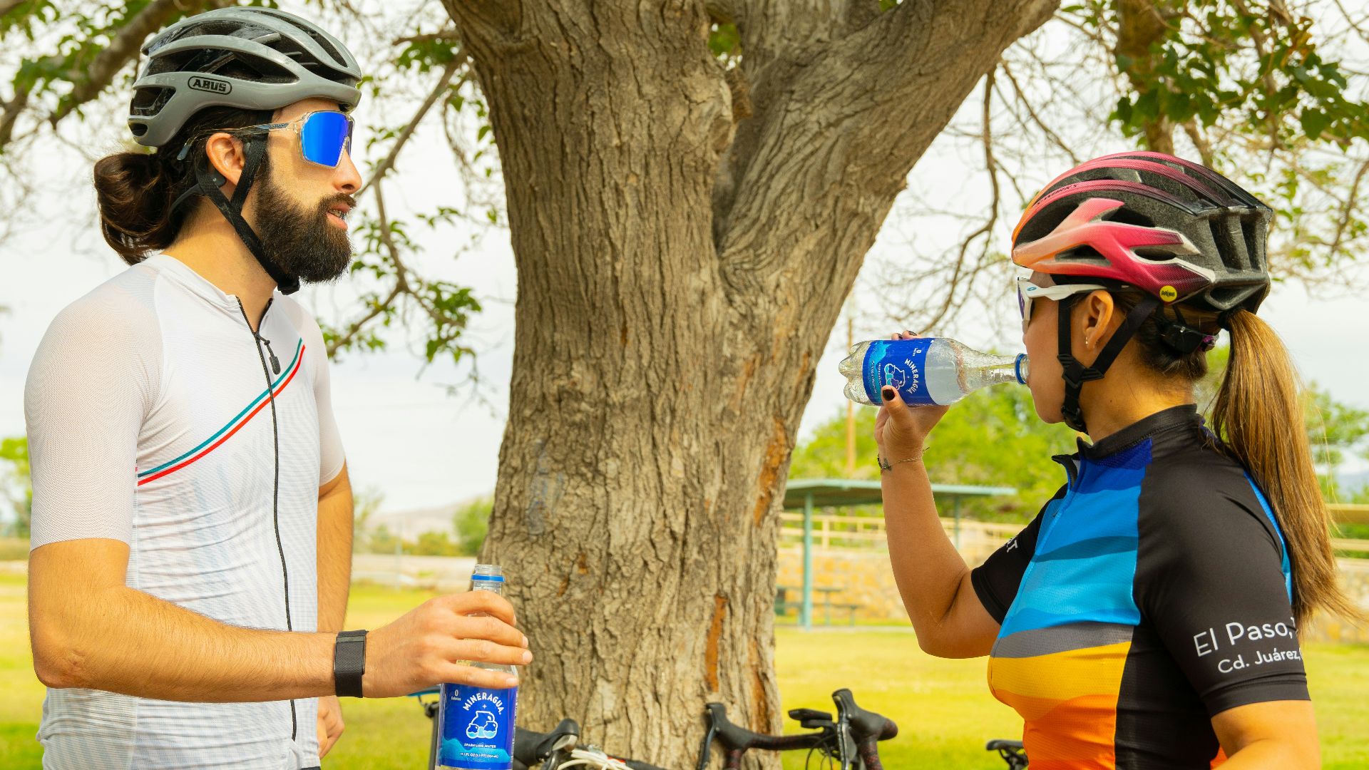 a man and a woman standing next to a tree