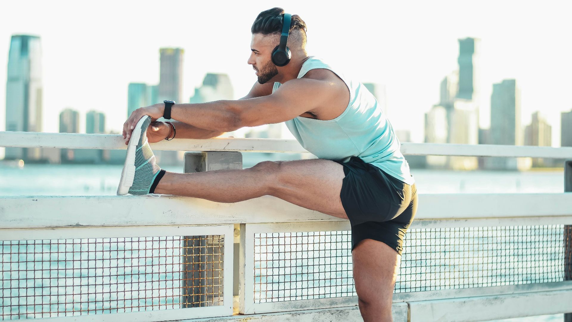 man in white tank top and black shorts doing push up during daytime