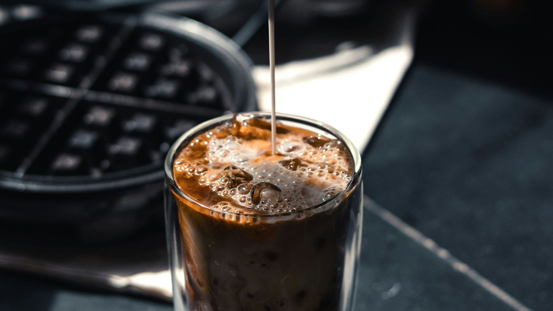 a person pours coffee into a glass