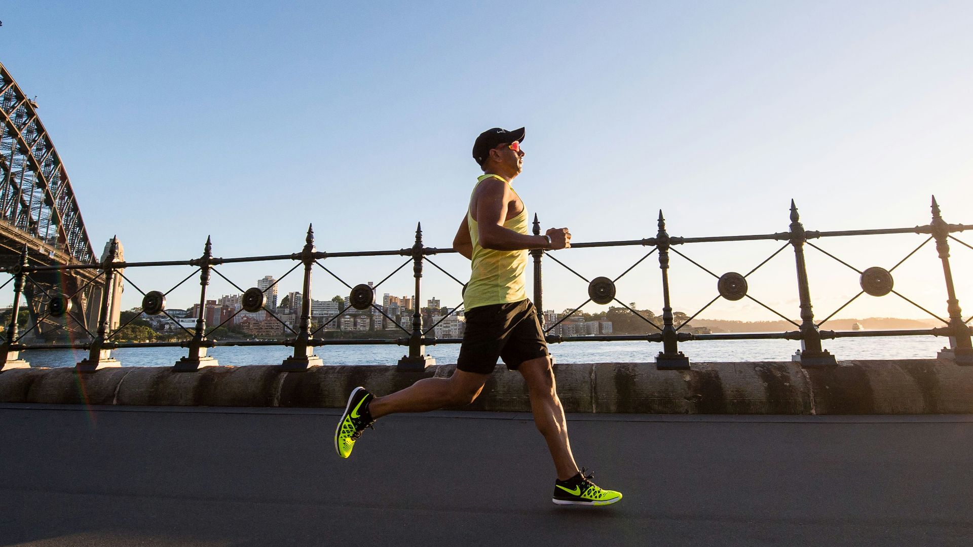 man in yellow tank top running near shore