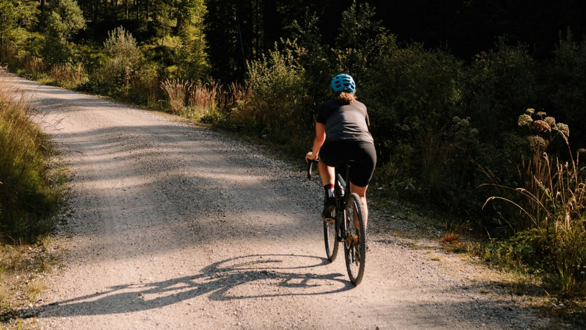 a man riding a bike down a dirt road