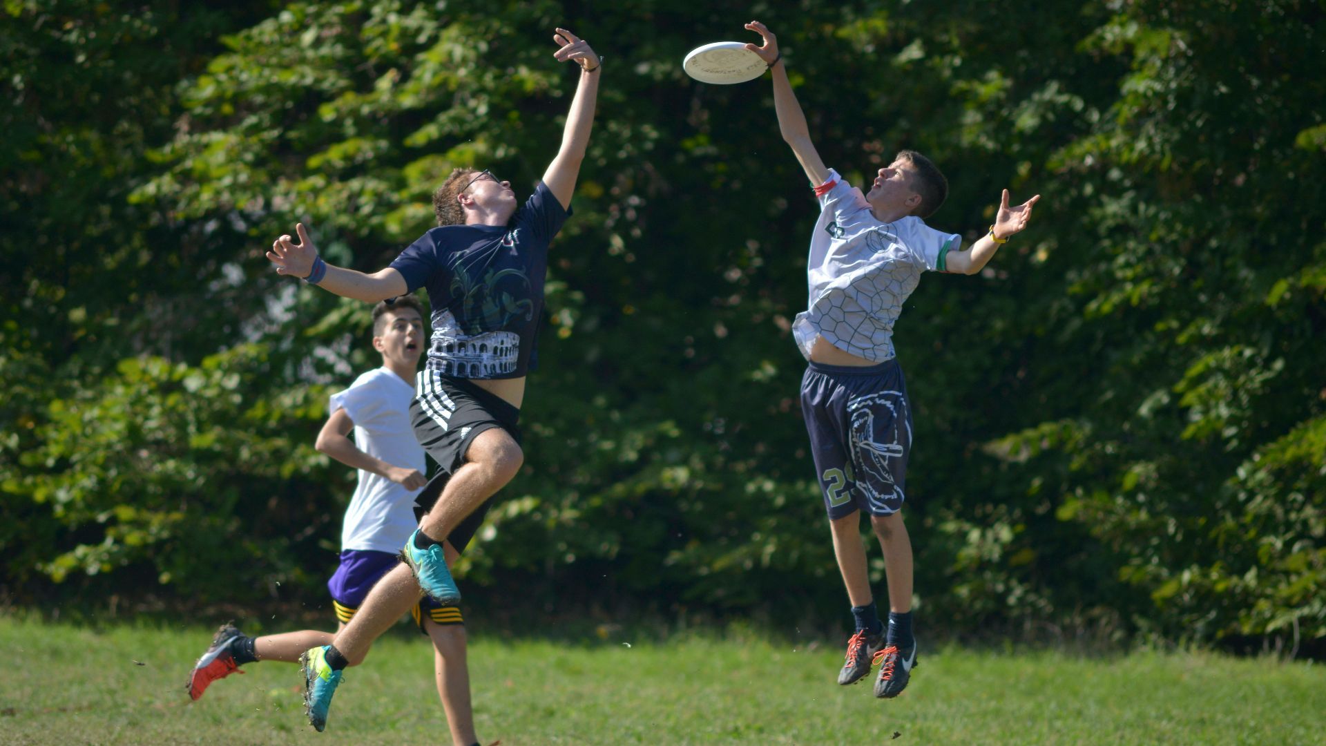 2 women playing soccer on green grass field during daytime