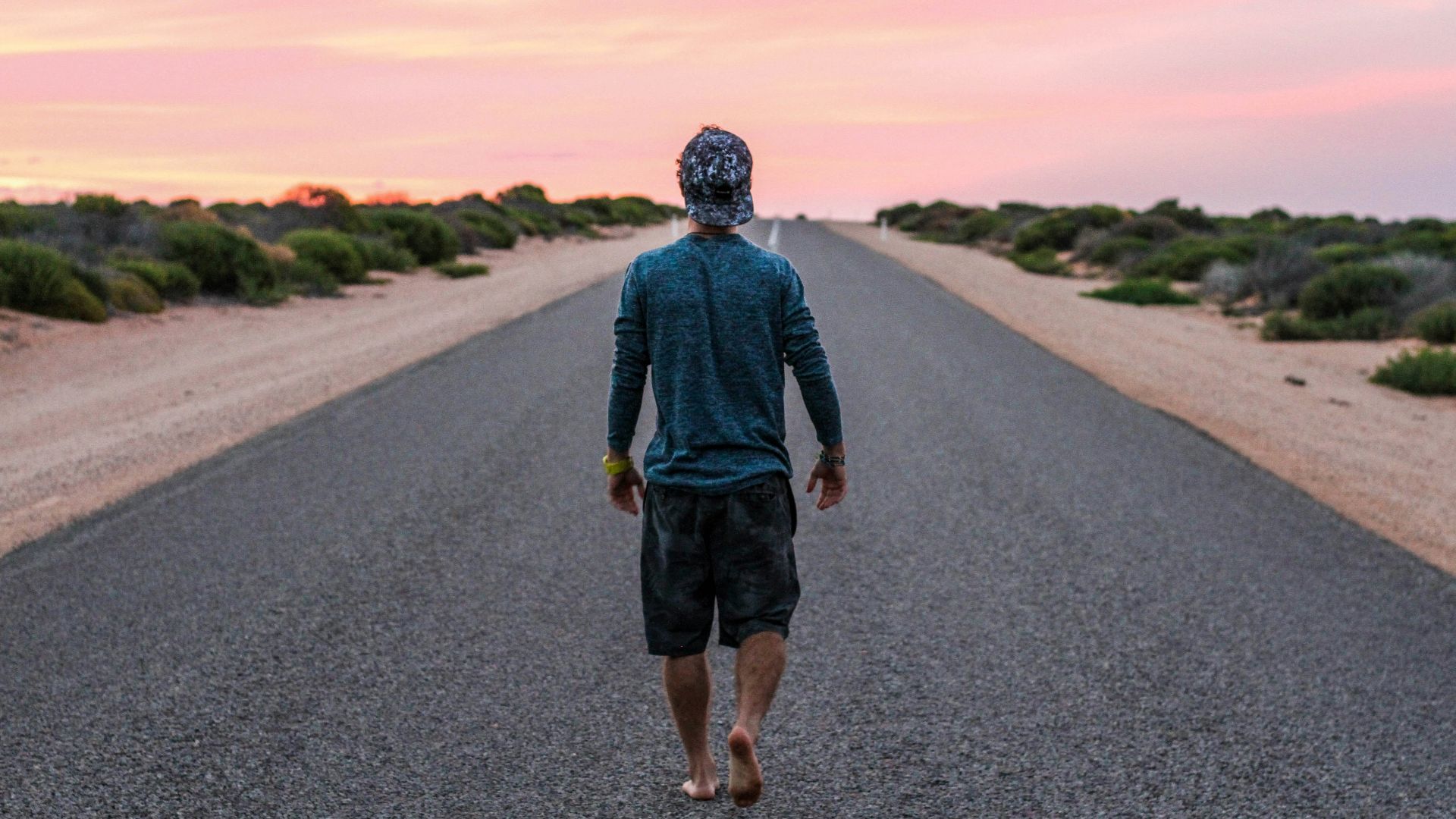 man walking on gray concrete road