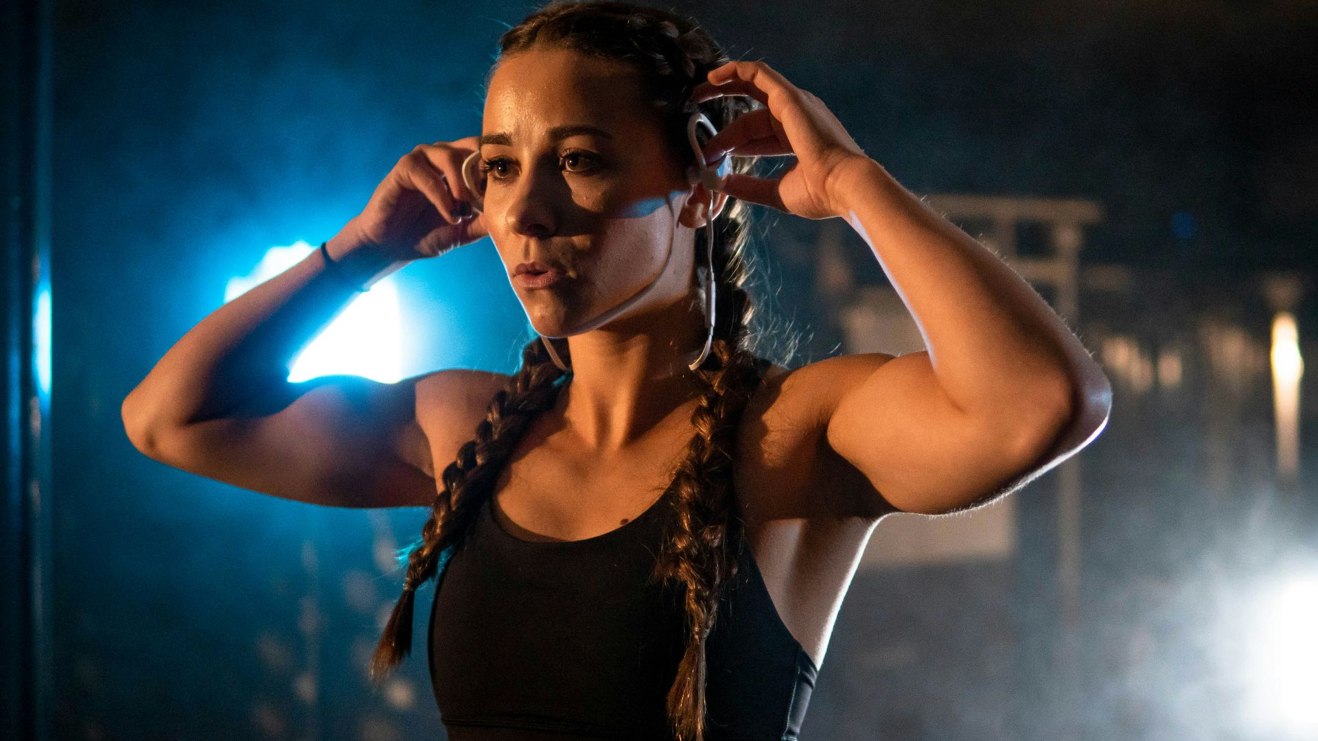 a woman in a black top is holding her hair