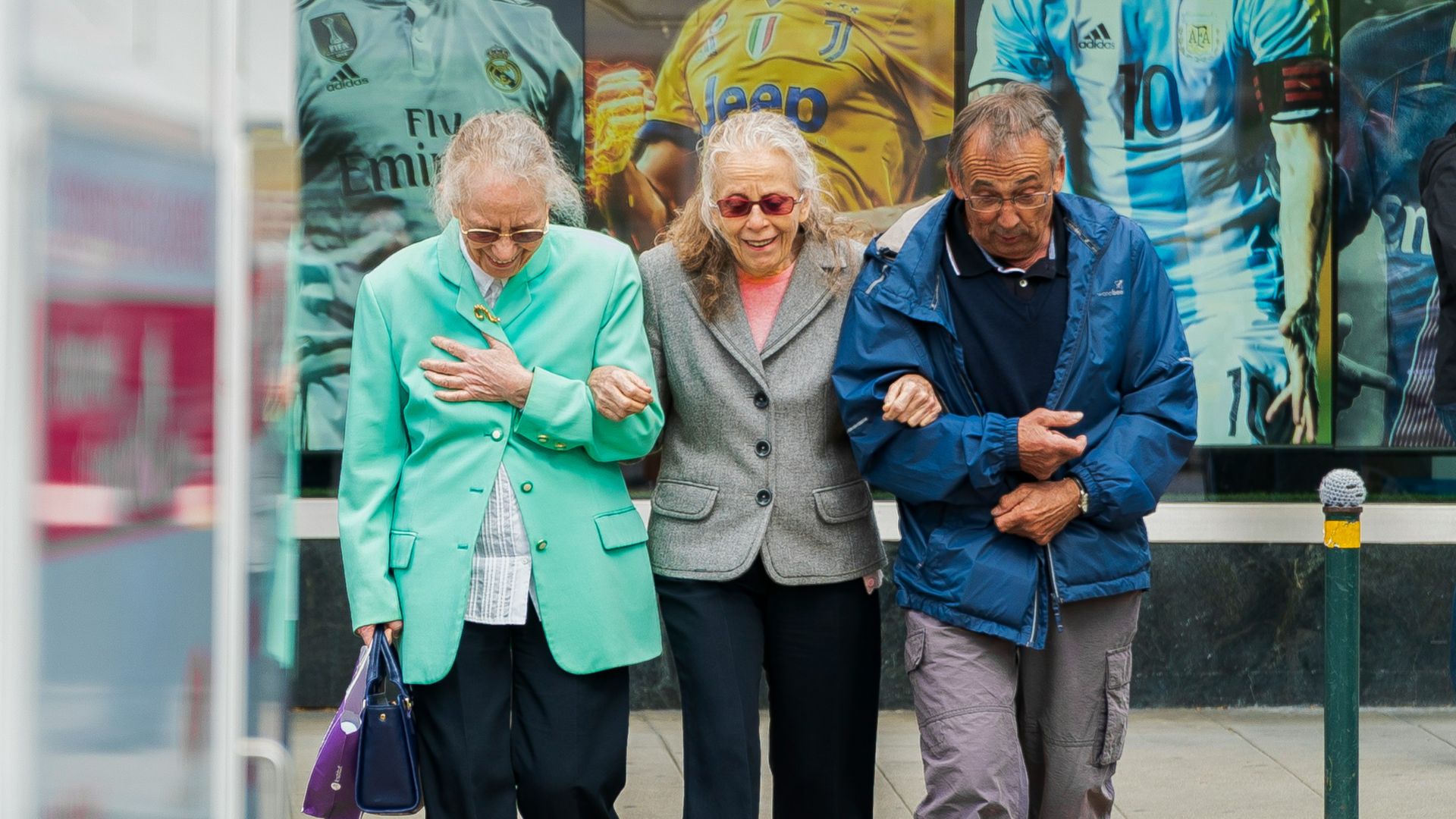 two women and man walking in the street during daytime