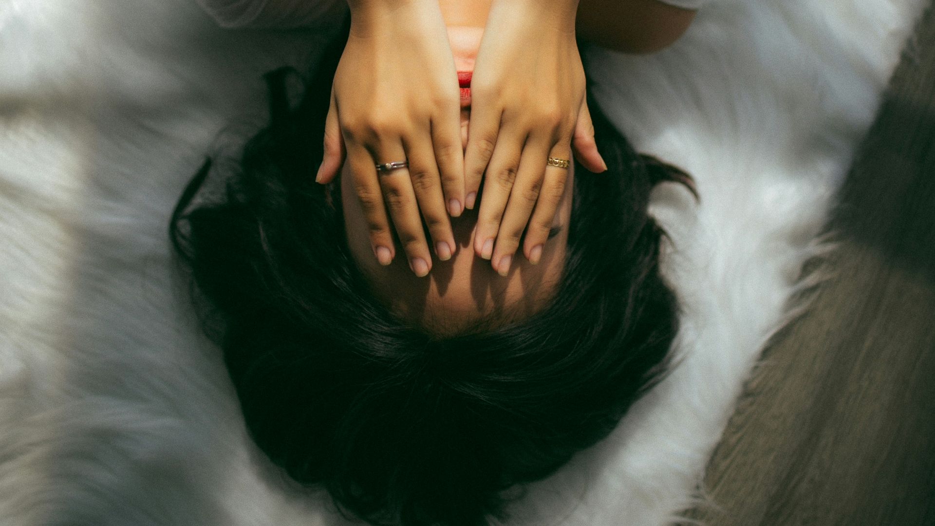 a woman holds her hands over her face