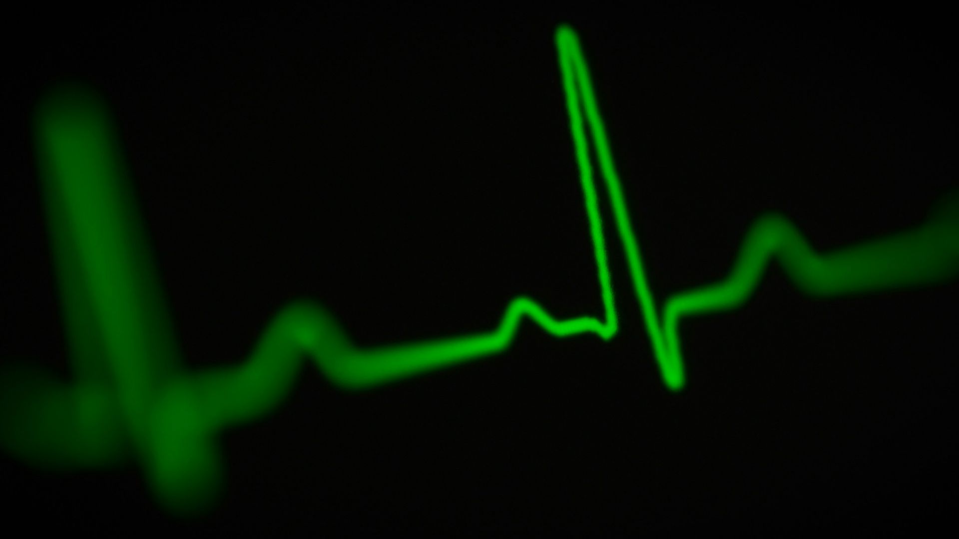 a green heart beat on a black background