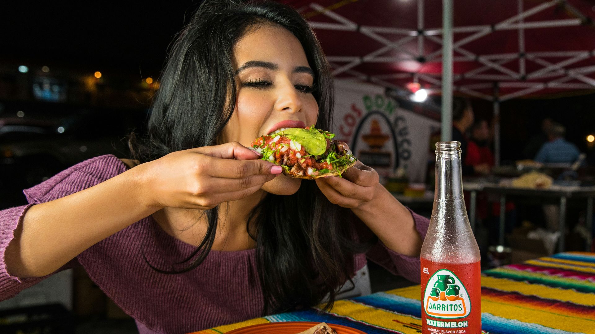 woman in purple shirt holding green and yellow floral ceramic bowl