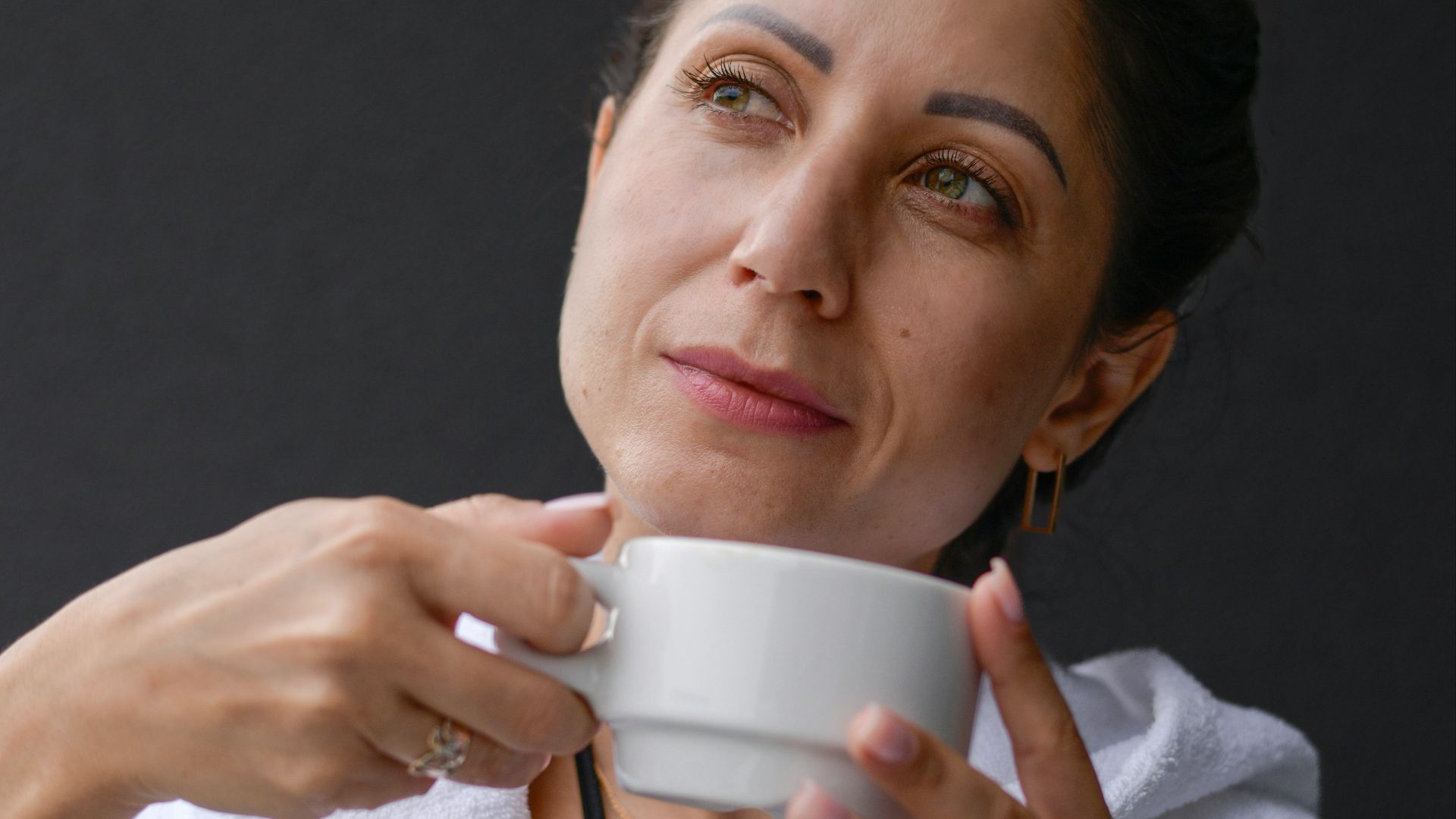 A woman is holding a cup of coffee