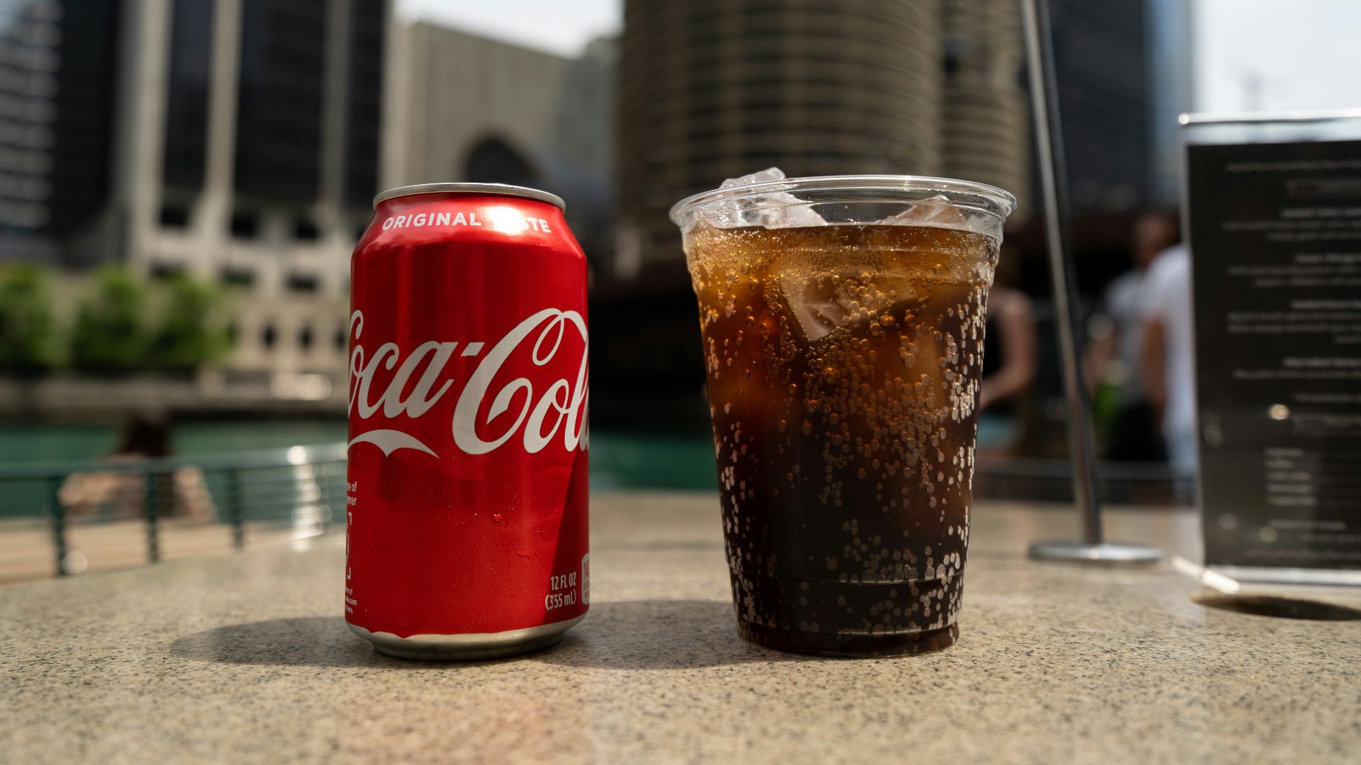 Coca-Cola soda tin can and cup on table close-up photography