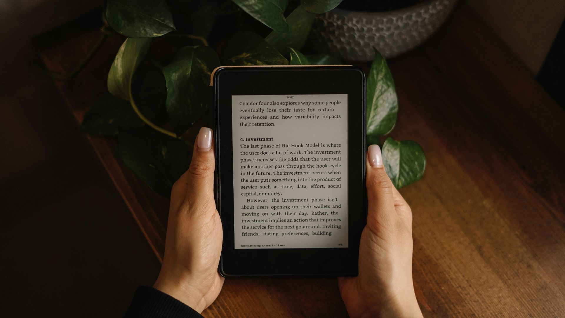 a person is holding a kindle on a table