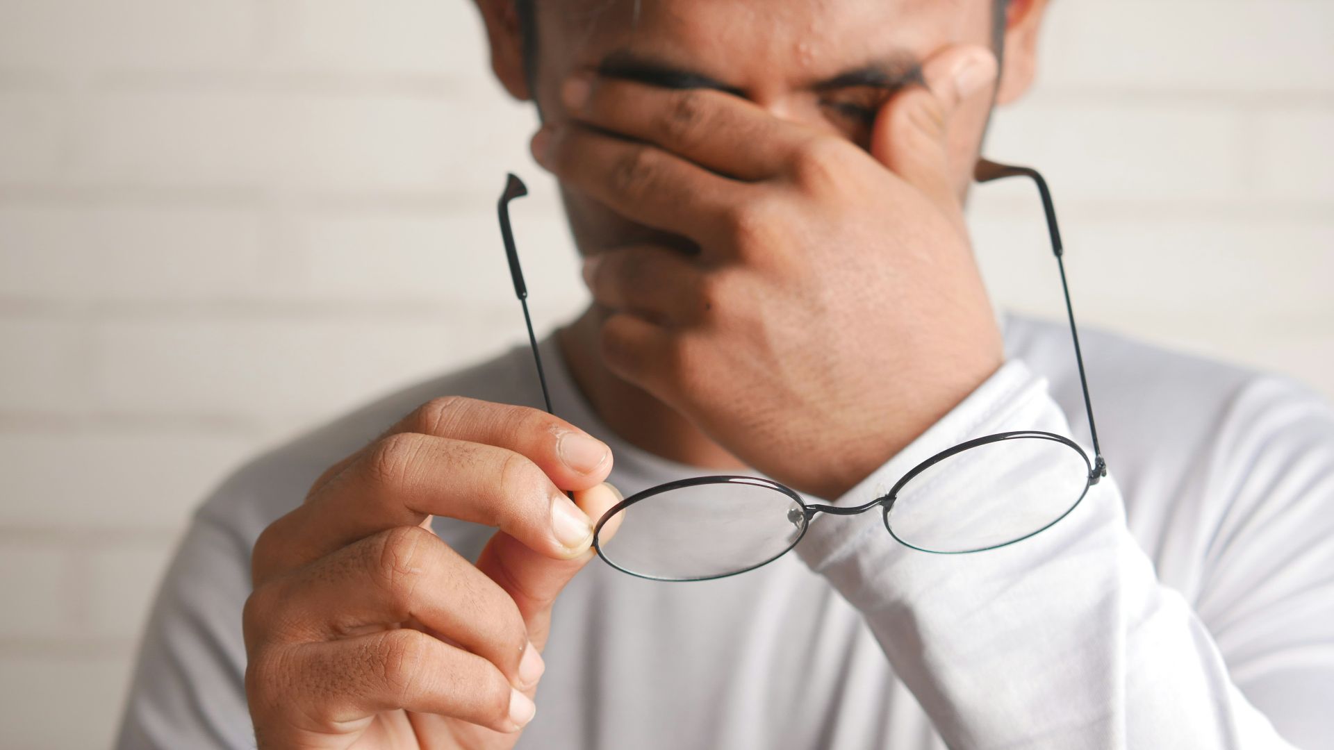 a man holding a pair of glasses up to his face