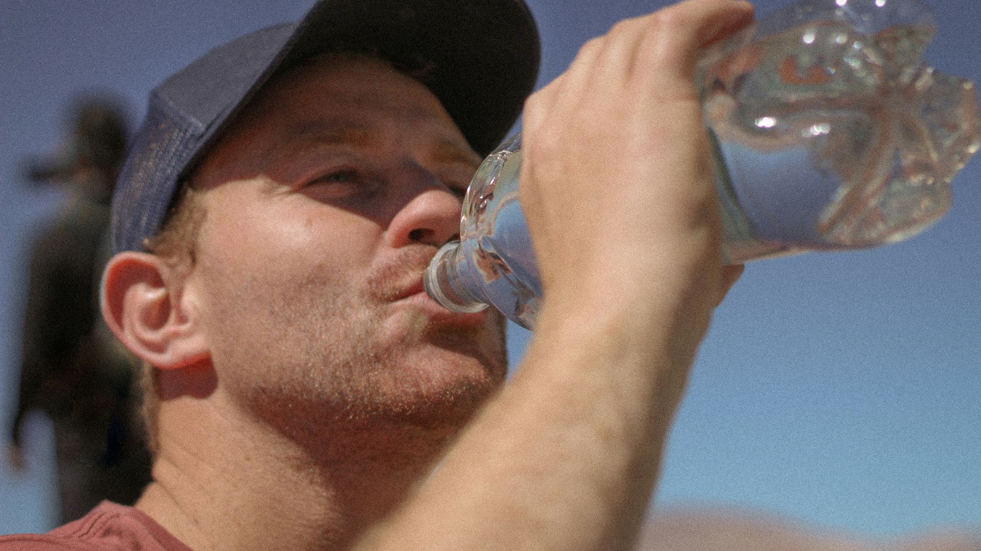 a man drinking water out of a bottle