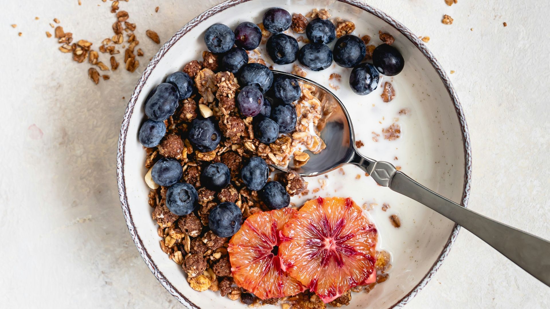 two bowls filled with granola and fruit on top of a table