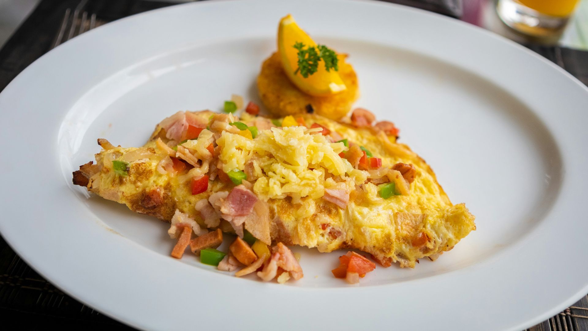 a white plate topped with an omelet next to a glass of orange juice