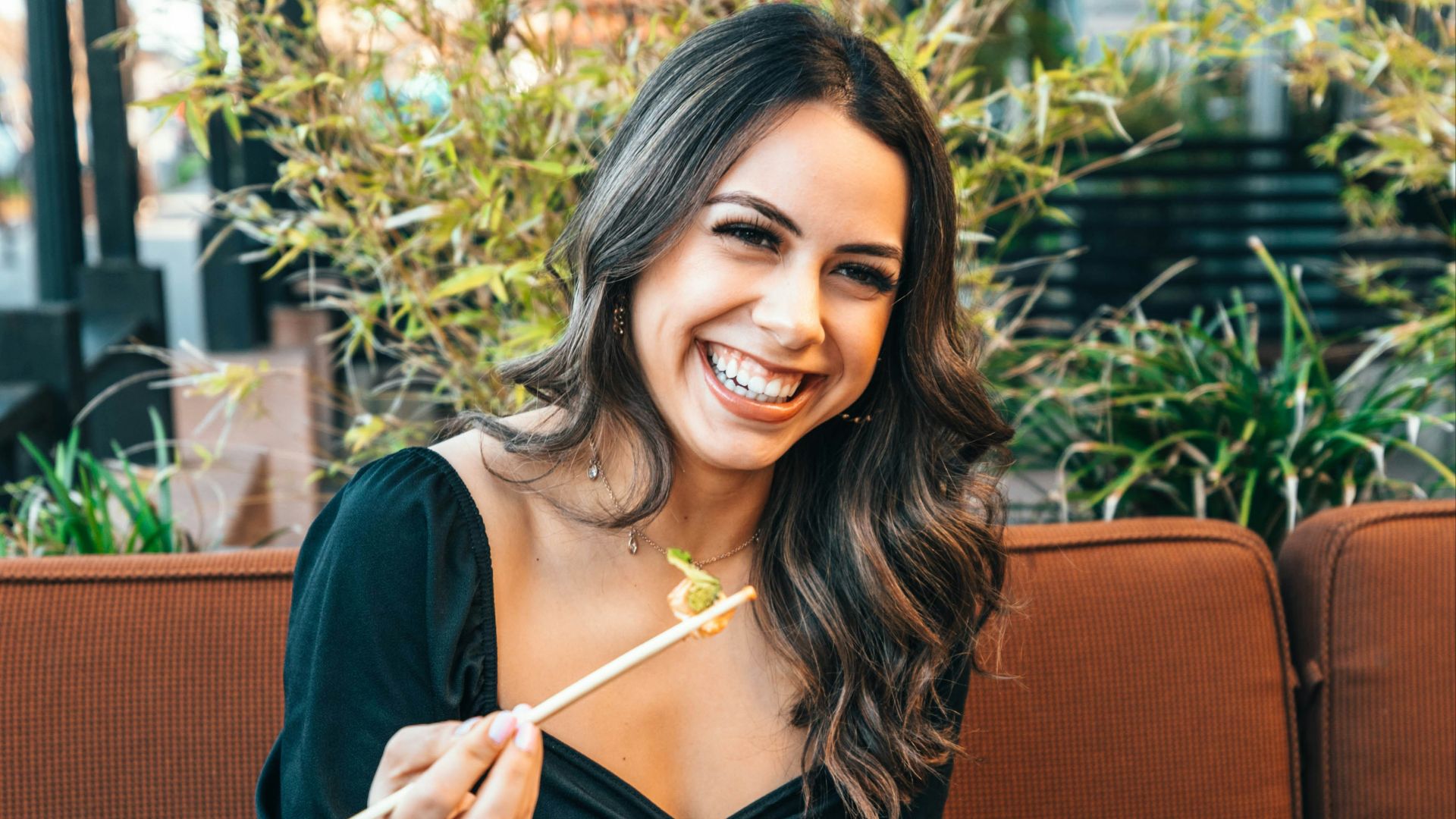 woman in blue long sleeve shirt holding chopsticks