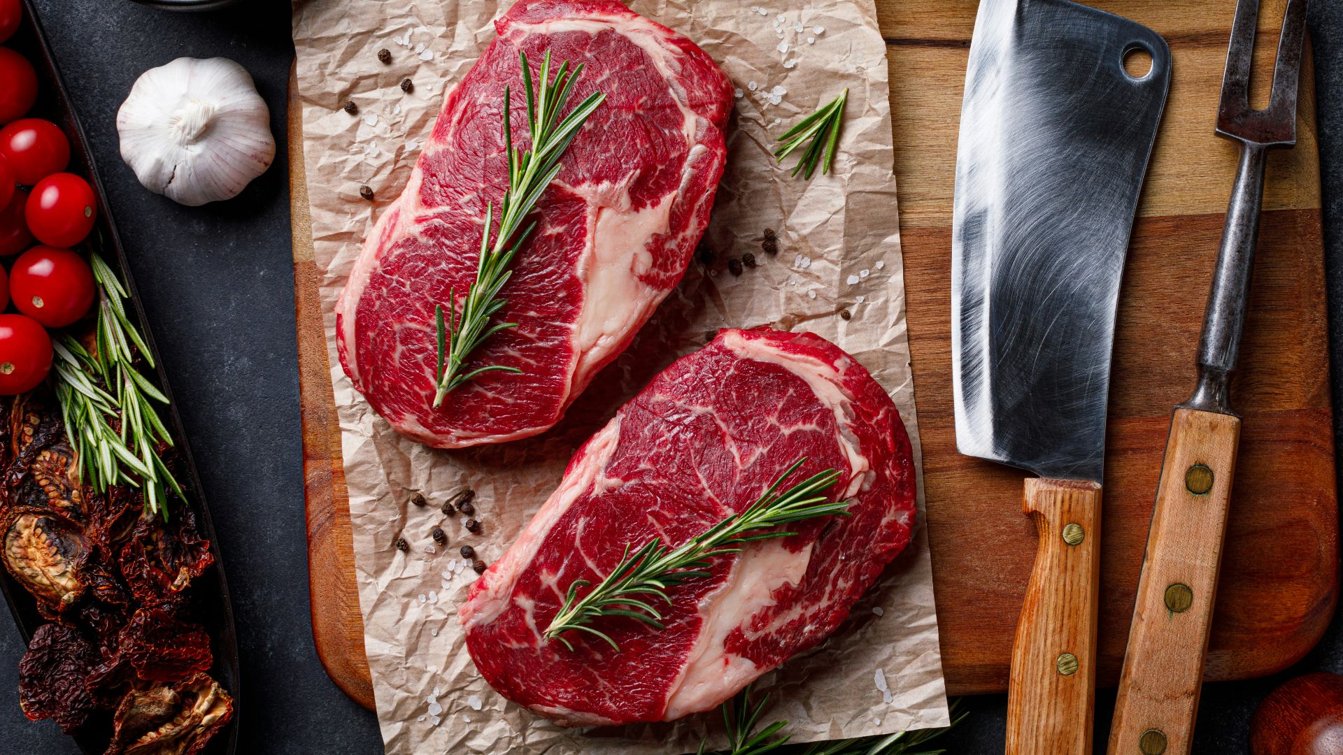 a cutting board topped with raw meat next to a knife