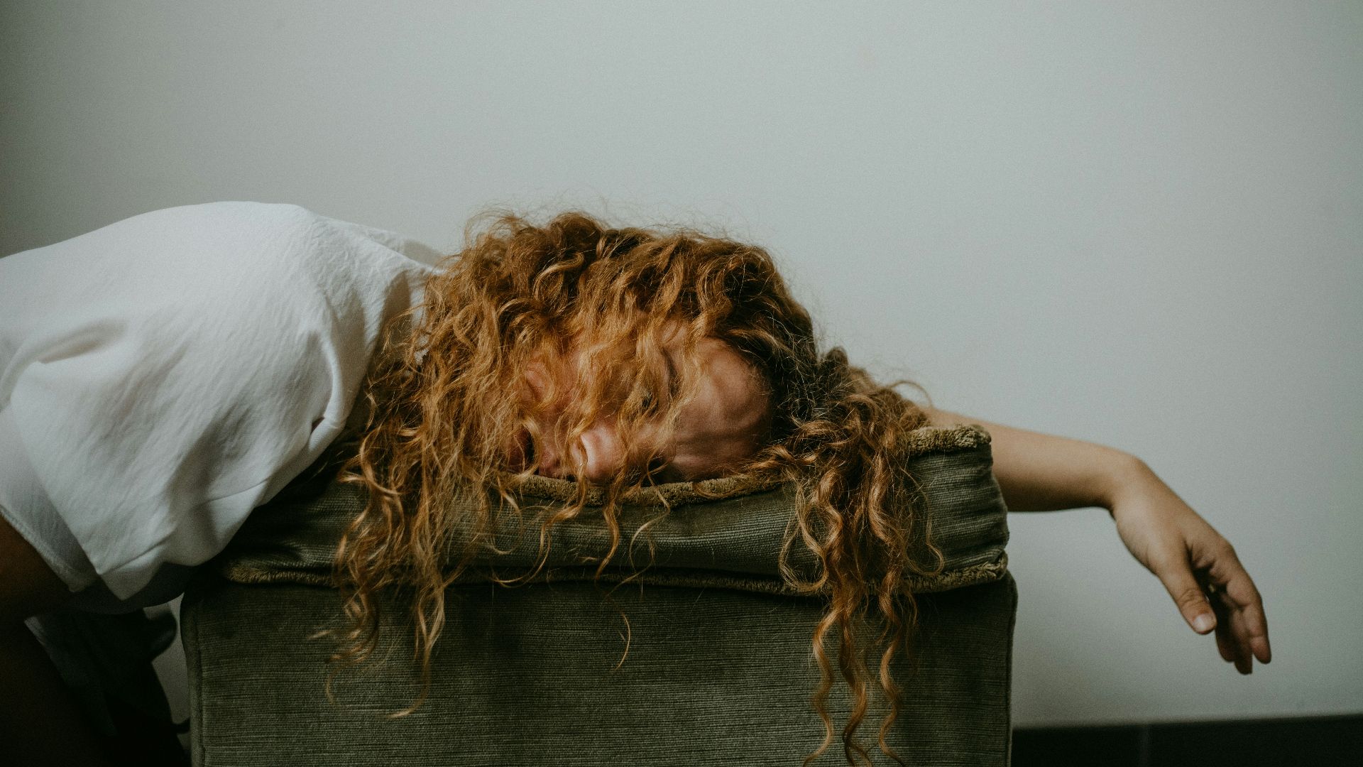 woman in white shirt lying on black textile