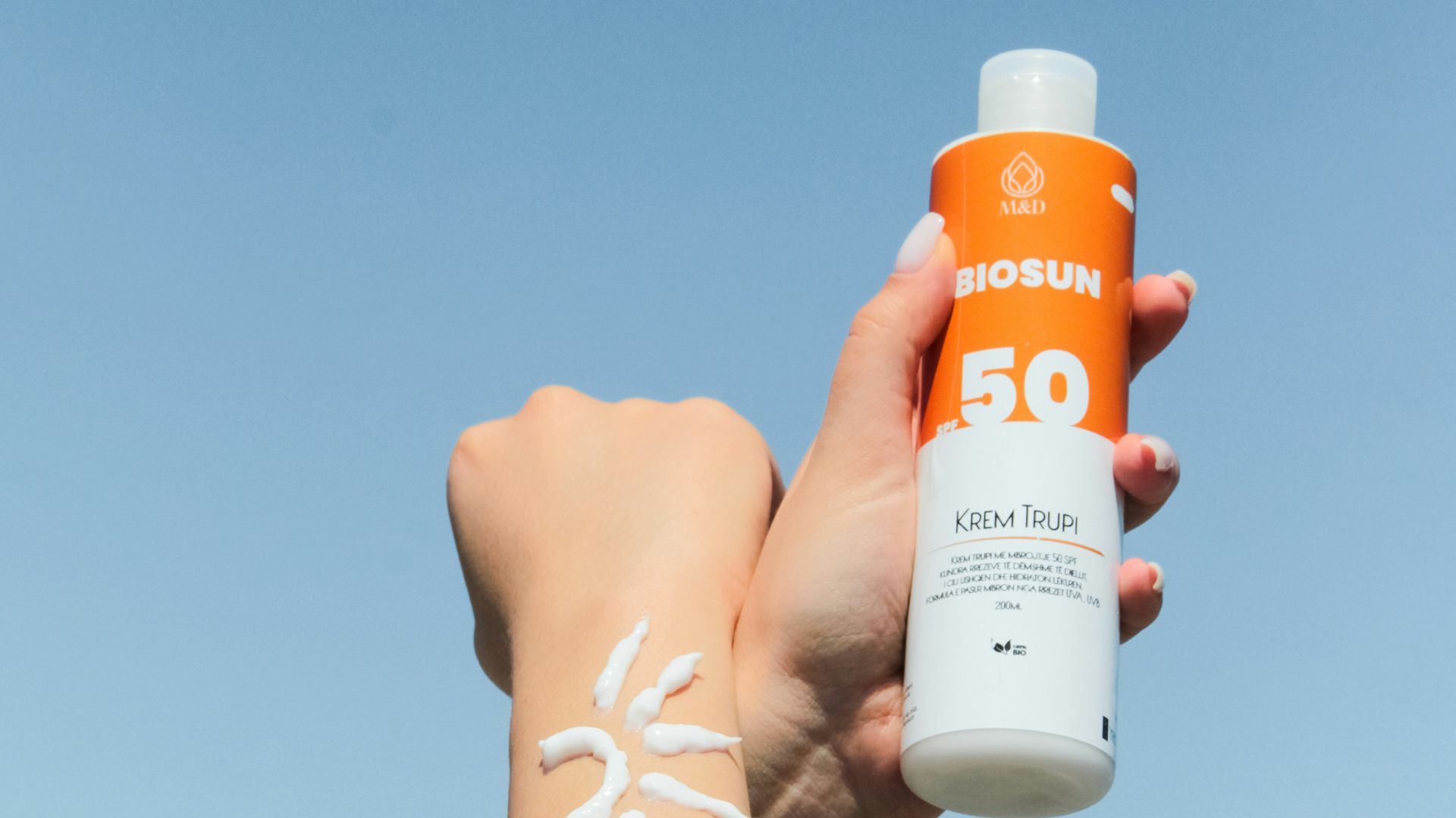 a person holding a bottle of sunscreen in their hand