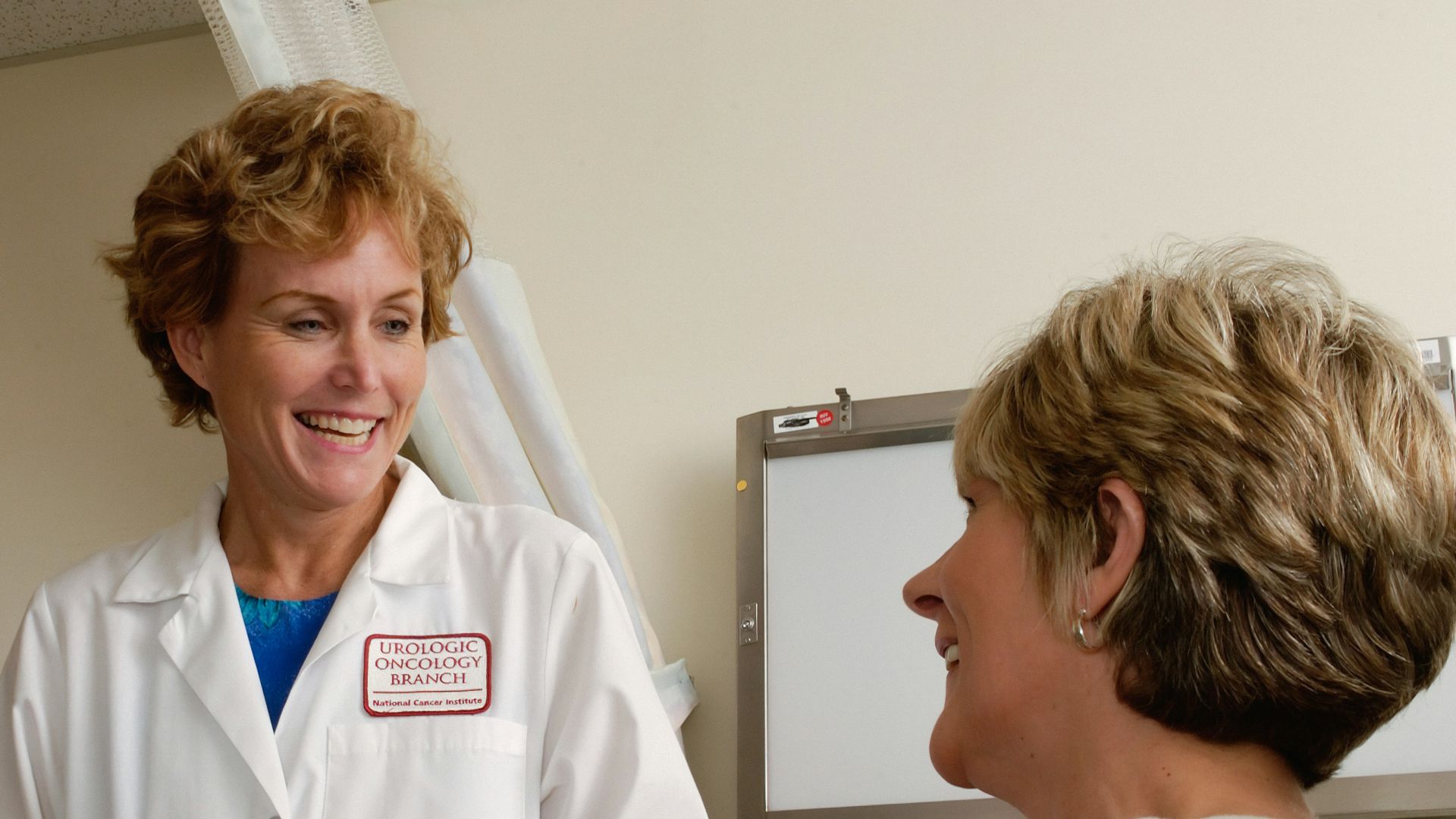 woman in white scrub suit holding gray laptop computer