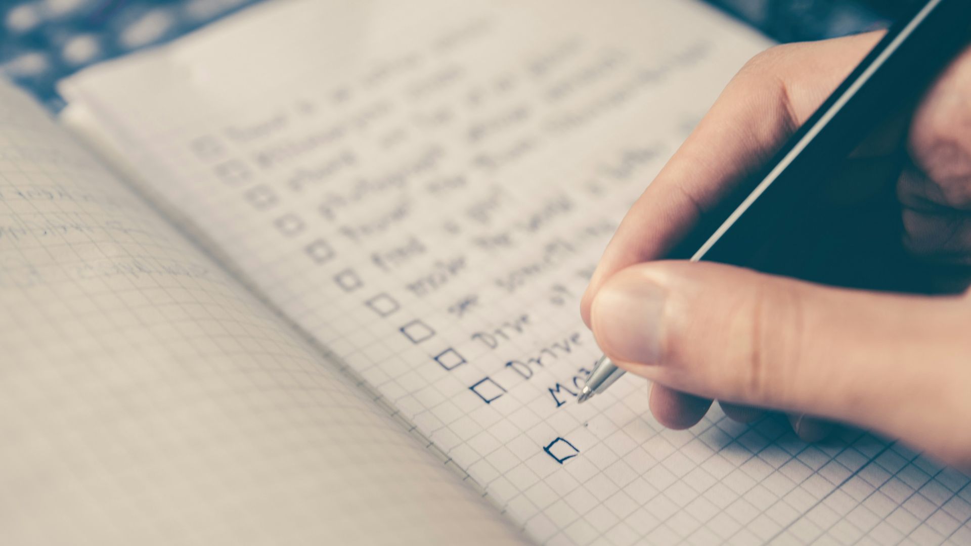 person writing bucket list on book