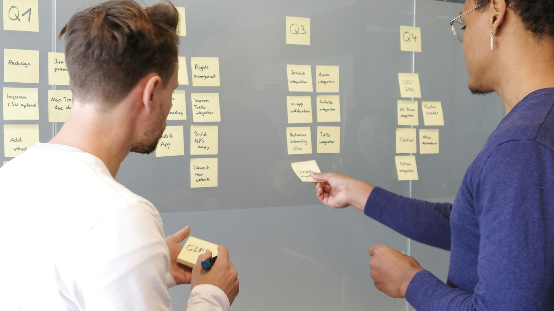 man in blue long sleeve shirt holding smartphone