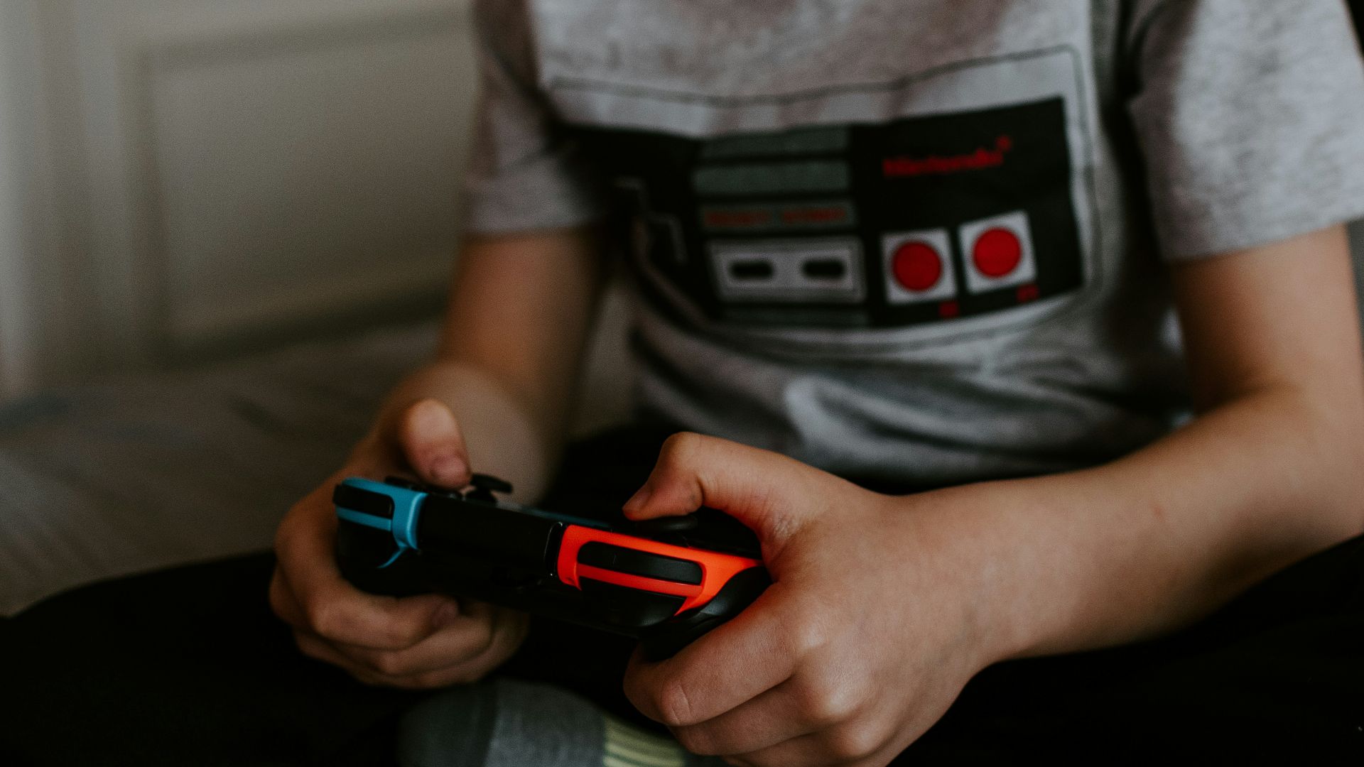 kid sitting on gray bed while playing