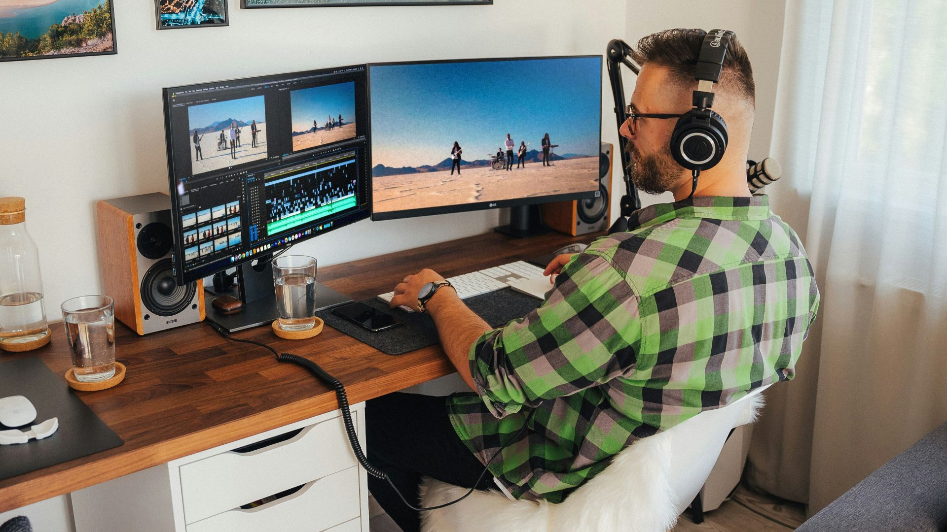 a person sitting at a desk with a computer and headphones on